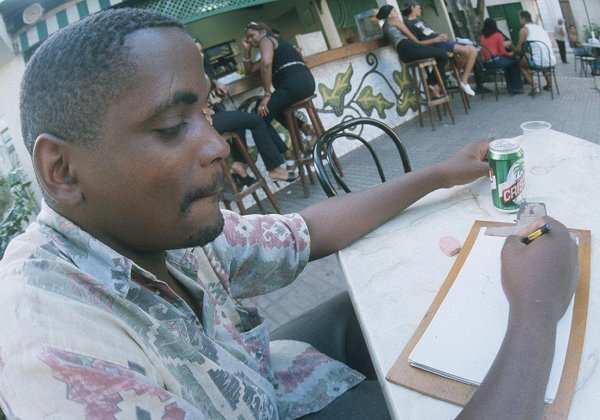 Guy drawing tourists for money at a cafe in Camag&uuml;ey